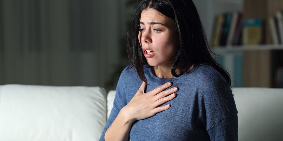 Woman Suffering An Anxiety Attack Alone In The Night On A Couch At Home